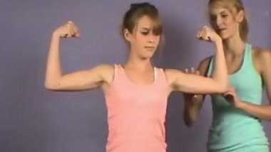 2 young girls comparing their muscles